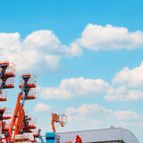 3 Red sheedy cranes in the sky, crane rental benefits concept image.